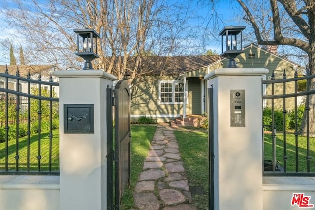 view of gate with a lawn