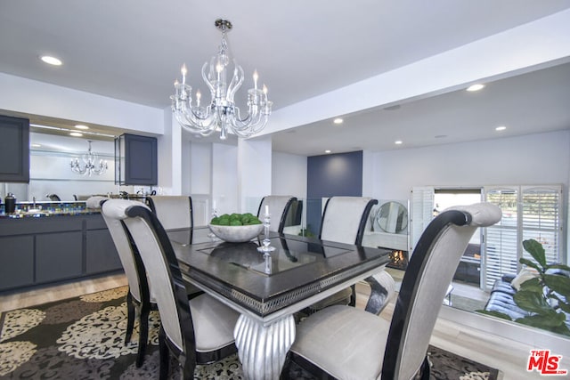 dining area with hardwood / wood-style floors and a chandelier