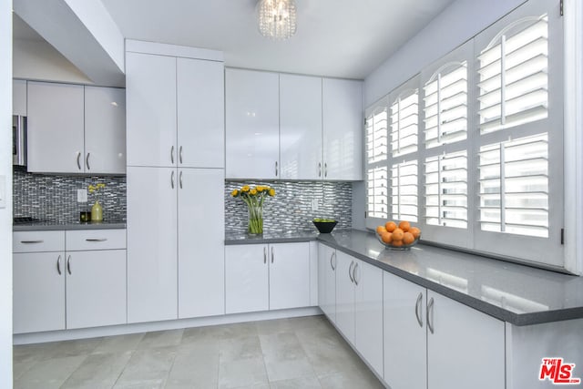 kitchen with decorative backsplash and white cabinets