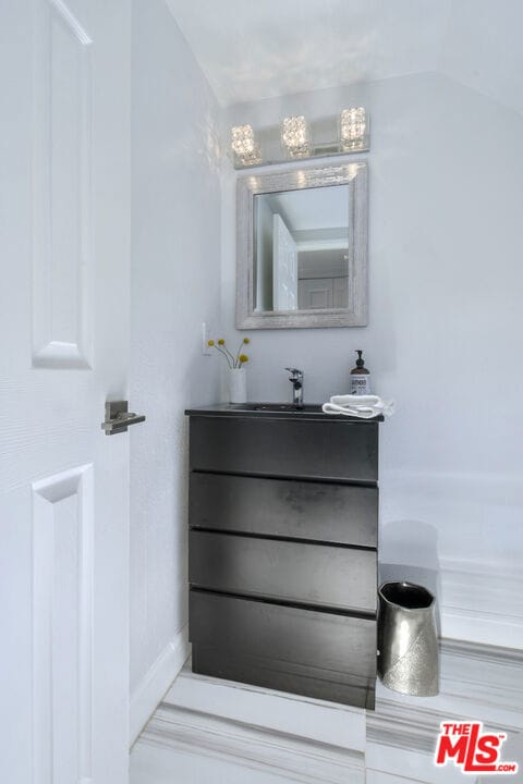 bathroom featuring vanity and vaulted ceiling