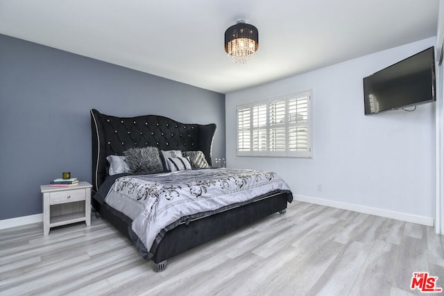 bedroom featuring a chandelier and light wood-type flooring