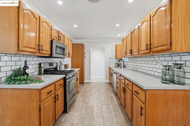 kitchen with sink, stainless steel appliances, tasteful backsplash, ornamental molding, and light wood-type flooring