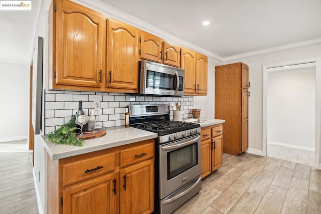 kitchen with tasteful backsplash, crown molding, light hardwood / wood-style flooring, and appliances with stainless steel finishes