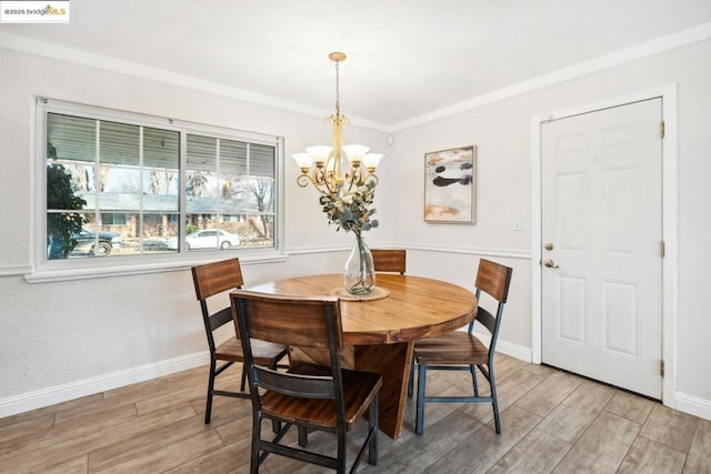 dining space featuring ornamental molding, a notable chandelier, and light hardwood / wood-style flooring