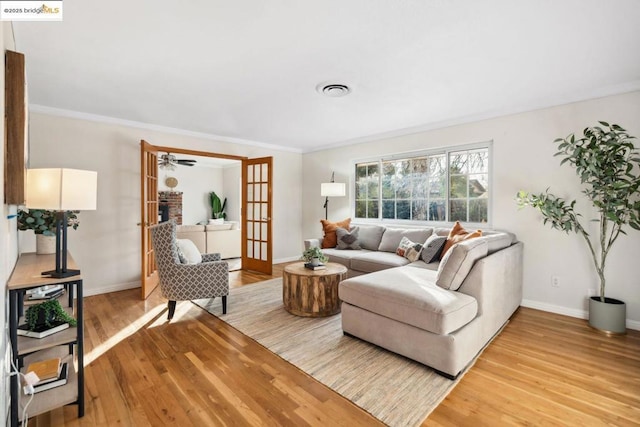 living room featuring french doors, ornamental molding, and hardwood / wood-style floors