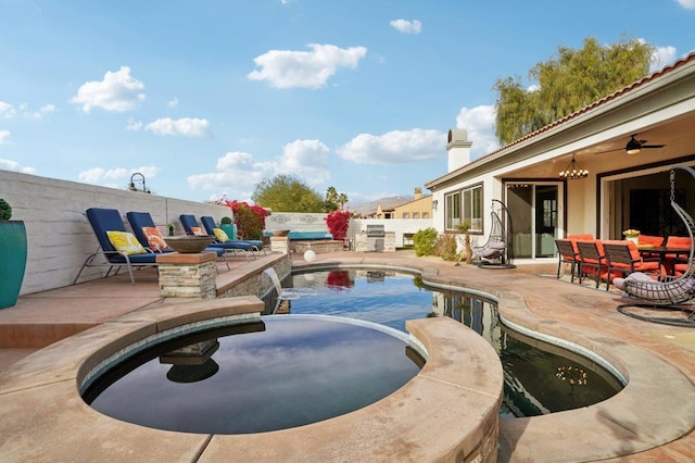 view of pool with pool water feature, ceiling fan, and a patio area