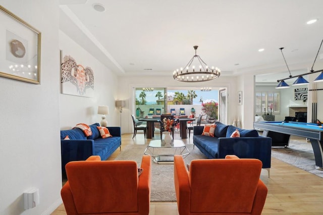 living room featuring a notable chandelier, pool table, and light wood-type flooring