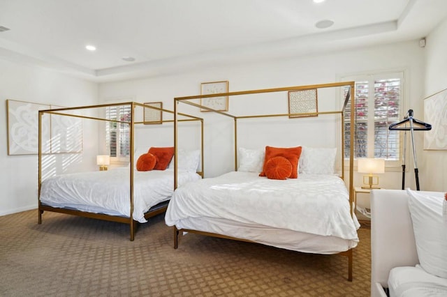 carpeted bedroom with a raised ceiling