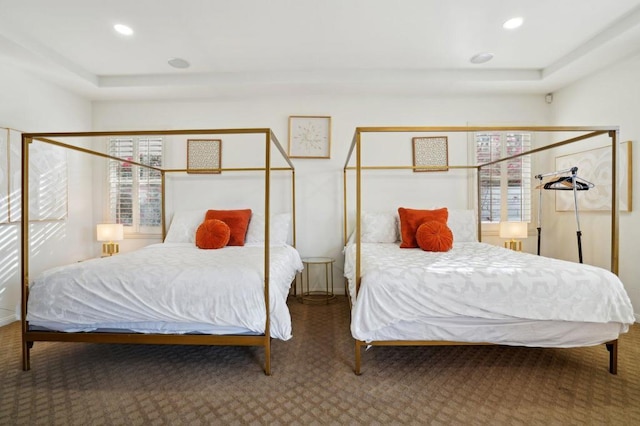 carpeted bedroom with a tray ceiling