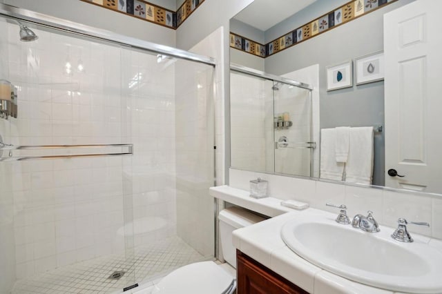 bathroom with a shower with door, vanity, and toilet