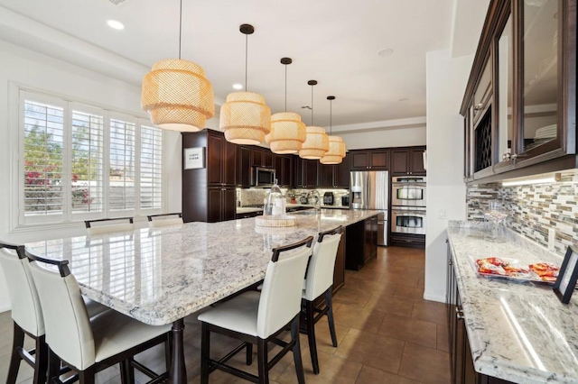 kitchen with pendant lighting, stainless steel appliances, and a large island