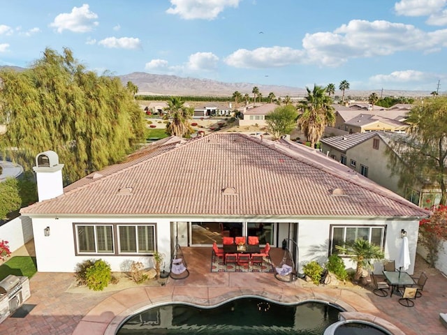 back of property featuring a mountain view and a patio