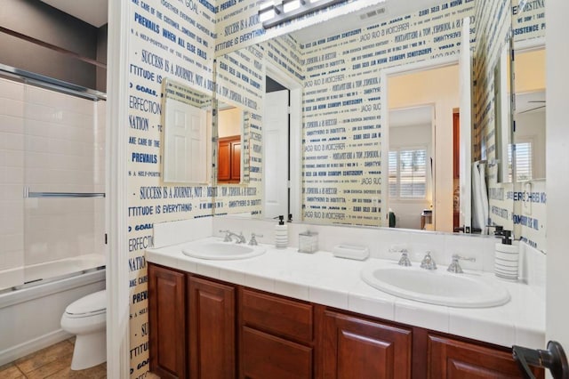 full bathroom with vanity, shower / bath combination with glass door, and toilet