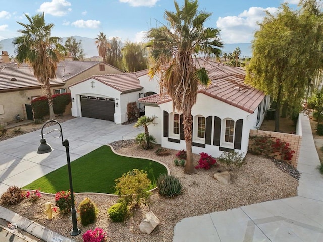 mediterranean / spanish house with a garage and a front lawn