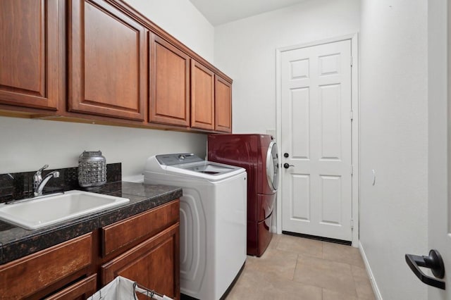 laundry area with cabinets, separate washer and dryer, sink, and light tile patterned floors