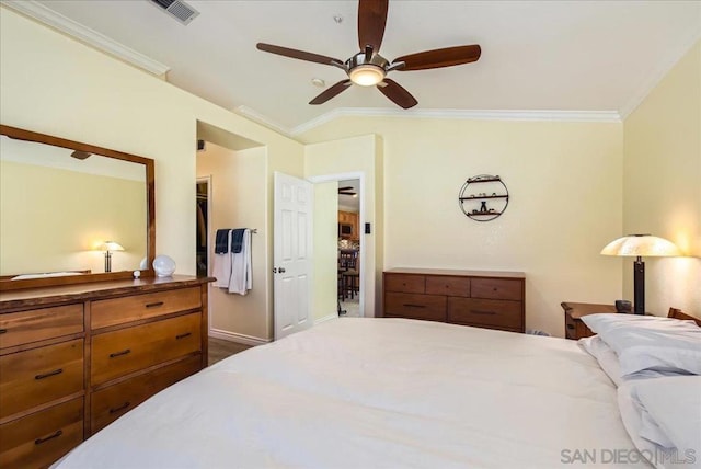 bedroom with vaulted ceiling, ornamental molding, a walk in closet, ceiling fan, and a closet