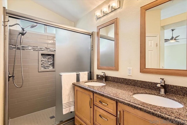 bathroom with vanity, vaulted ceiling, a shower with shower door, and ceiling fan