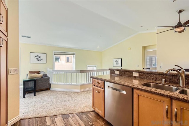 kitchen featuring dark wood-type flooring, sink, vaulted ceiling, dark stone countertops, and dishwasher