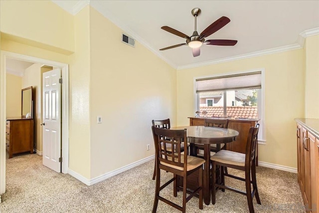 dining area featuring ceiling fan, light colored carpet, and ornamental molding