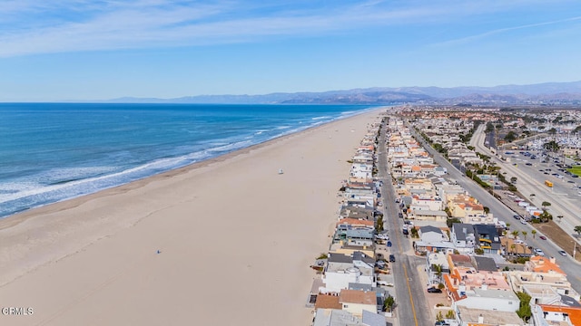 drone / aerial view featuring a view of the beach and a water and mountain view