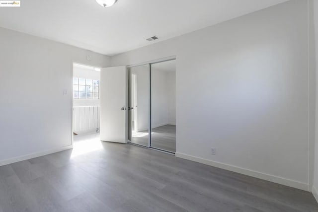 unfurnished bedroom with wood-type flooring and a closet