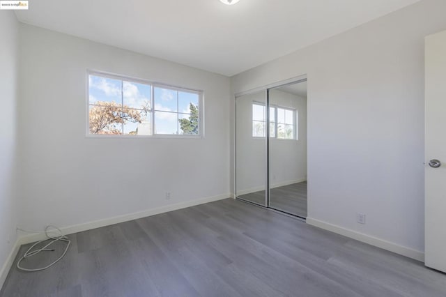 unfurnished bedroom with hardwood / wood-style floors and a closet