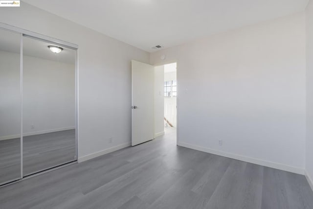 unfurnished bedroom with hardwood / wood-style flooring and a closet