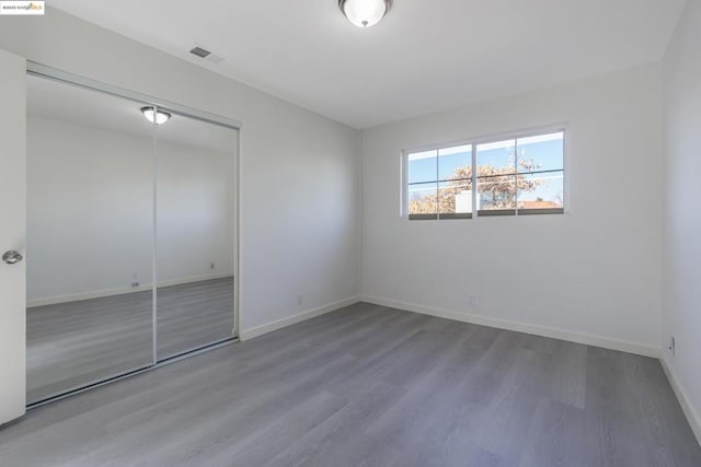 unfurnished bedroom featuring hardwood / wood-style floors and a closet