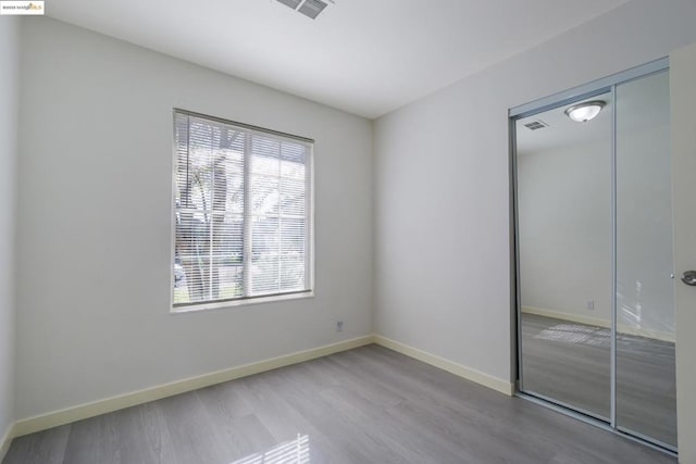 unfurnished bedroom featuring hardwood / wood-style flooring and a closet