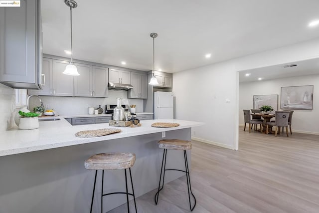 kitchen featuring gray cabinets, white fridge, sink, and pendant lighting