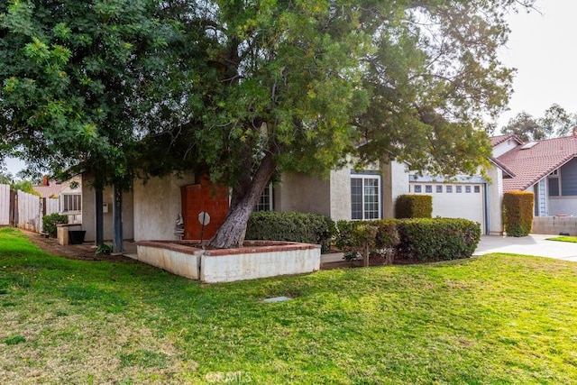 view of property hidden behind natural elements featuring a garage, a front lawn, concrete driveway, and stucco siding