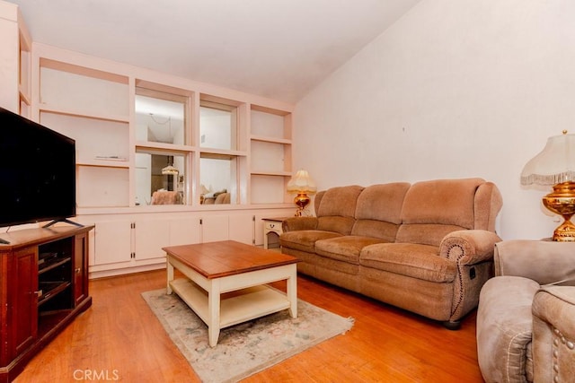 living room with vaulted ceiling and light wood-style flooring