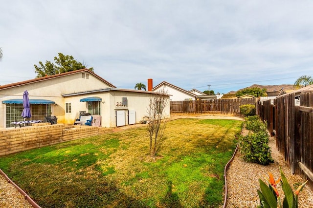 back of property featuring a yard, a fenced backyard, and stucco siding