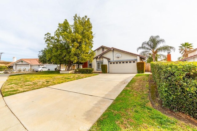 view of front of house with stucco siding, an attached garage, a front yard, fence, and driveway