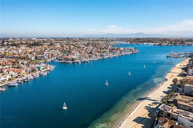 drone / aerial view featuring a water and mountain view and a beach view