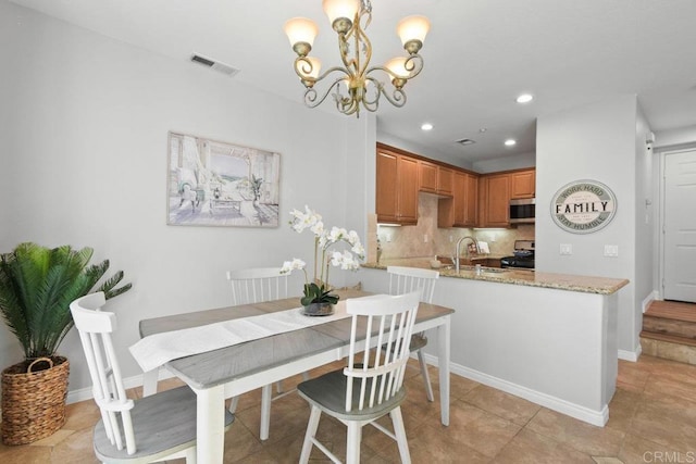 tiled dining room with sink and a chandelier