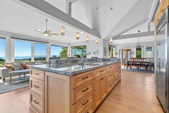 kitchen with high end refrigerator, light brown cabinetry, light hardwood / wood-style floors, and hanging light fixtures