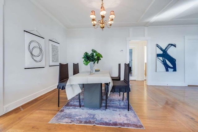 dining space with crown molding, a chandelier, and light hardwood / wood-style floors