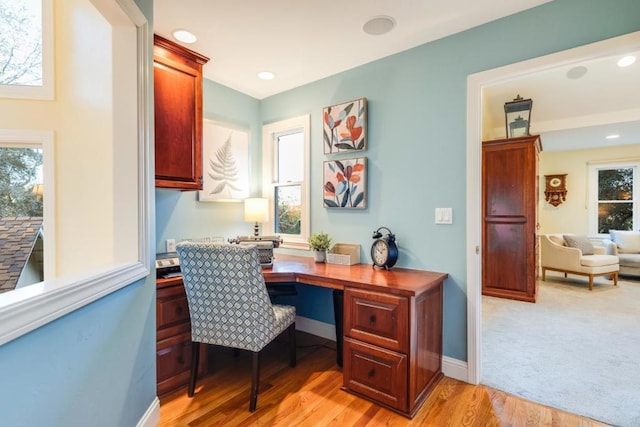 home office featuring built in desk and light wood-type flooring