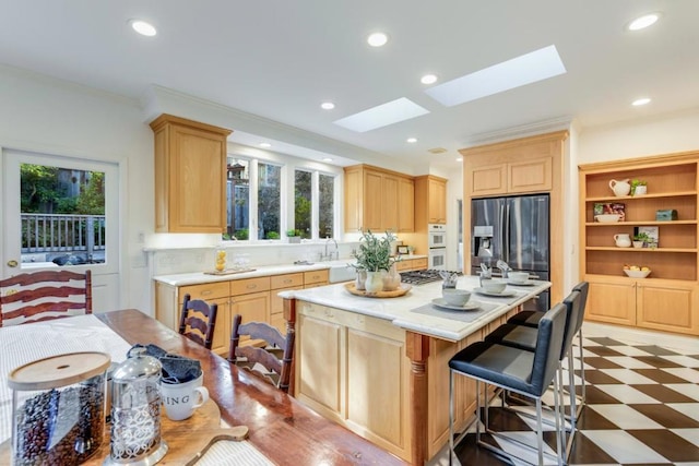 kitchen with stainless steel fridge with ice dispenser, a wealth of natural light, a skylight, and a center island with sink