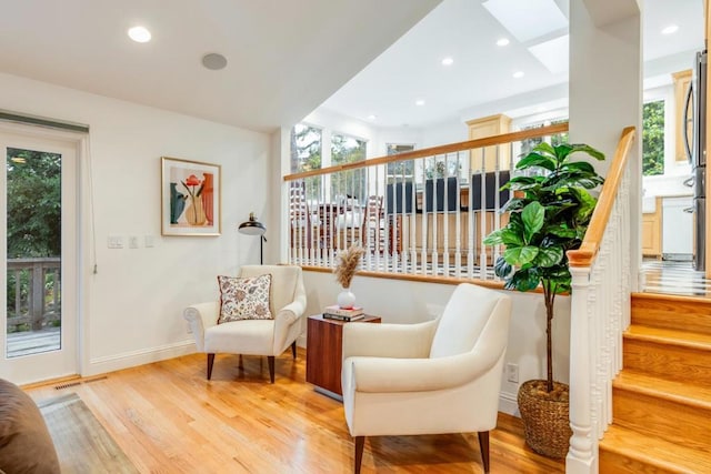 living area with a skylight and light wood-type flooring