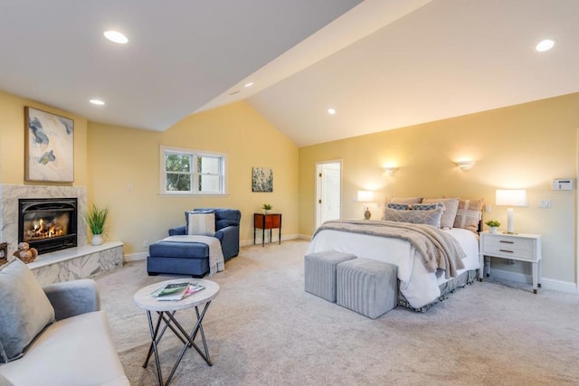 carpeted bedroom with lofted ceiling and a premium fireplace