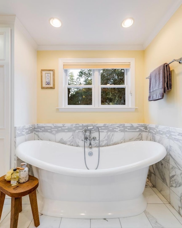 bathroom featuring tile walls, a bath, and crown molding