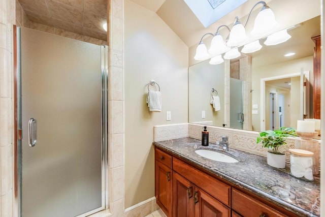 bathroom with vanity, a skylight, and a shower with shower door