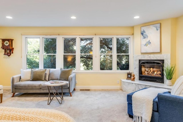 living room with light colored carpet and a premium fireplace