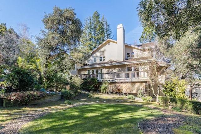 rear view of property featuring a yard and a deck