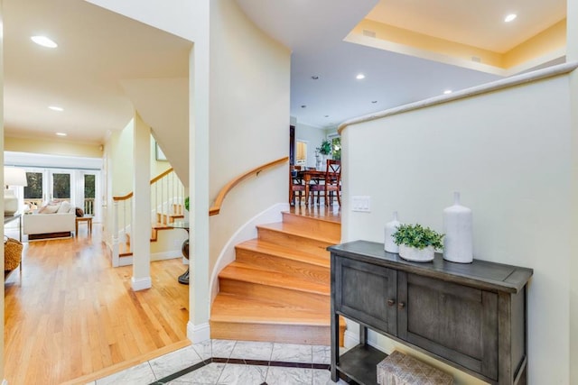 staircase featuring a raised ceiling