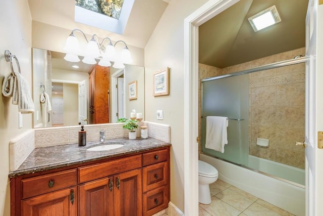 full bathroom with a skylight, enclosed tub / shower combo, vanity, toilet, and tile patterned floors