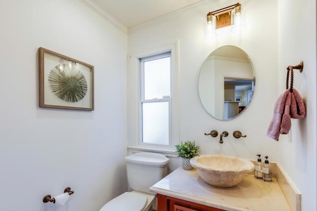 bathroom featuring vanity, ornamental molding, and toilet