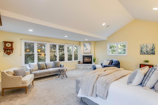 bedroom with light colored carpet, lofted ceiling, and multiple windows